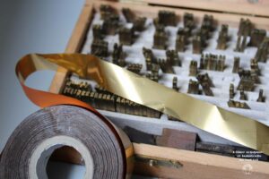 Un ruban d'or et quelques poinçons au second plan
